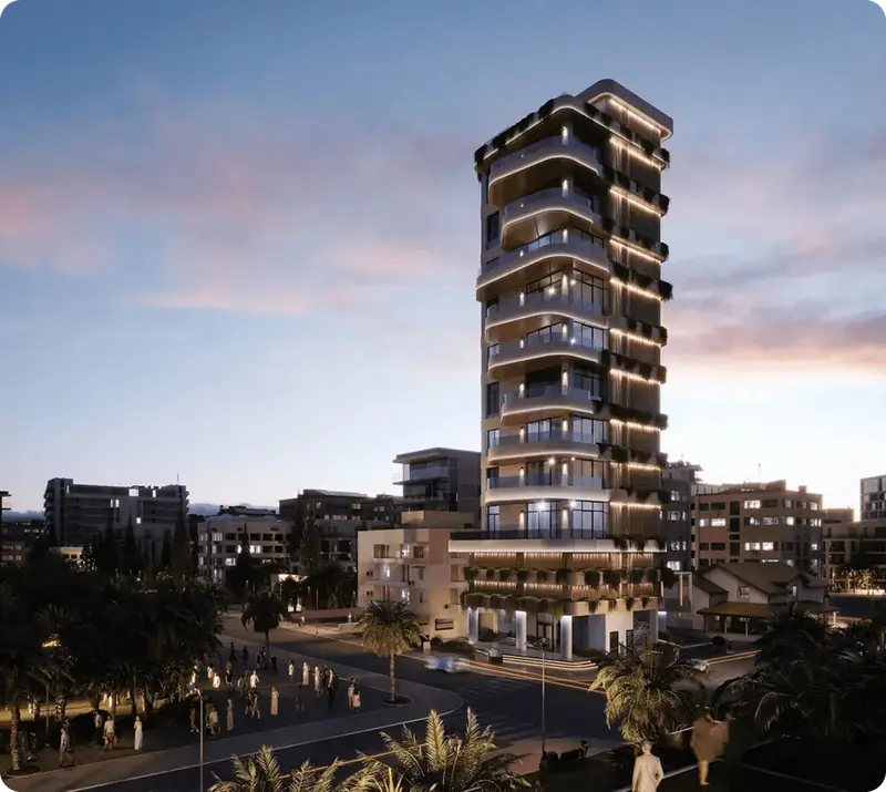Modern high-rise residential building lit up at dusk above a palm-lined street.