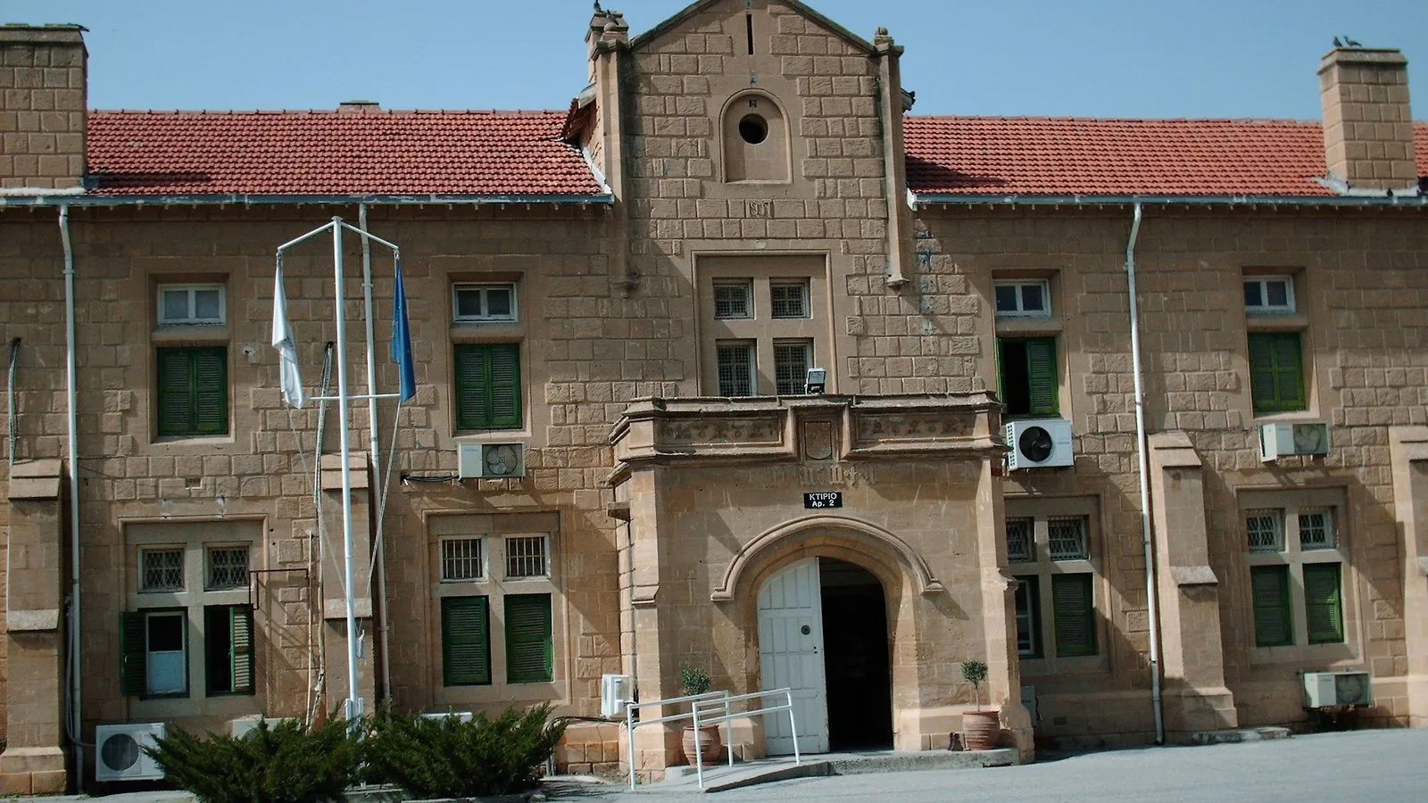 One of the Nicosia Law Court buildings facing the courtyard of the courts compound in Cyprus, pale stone facade under a clear sky.